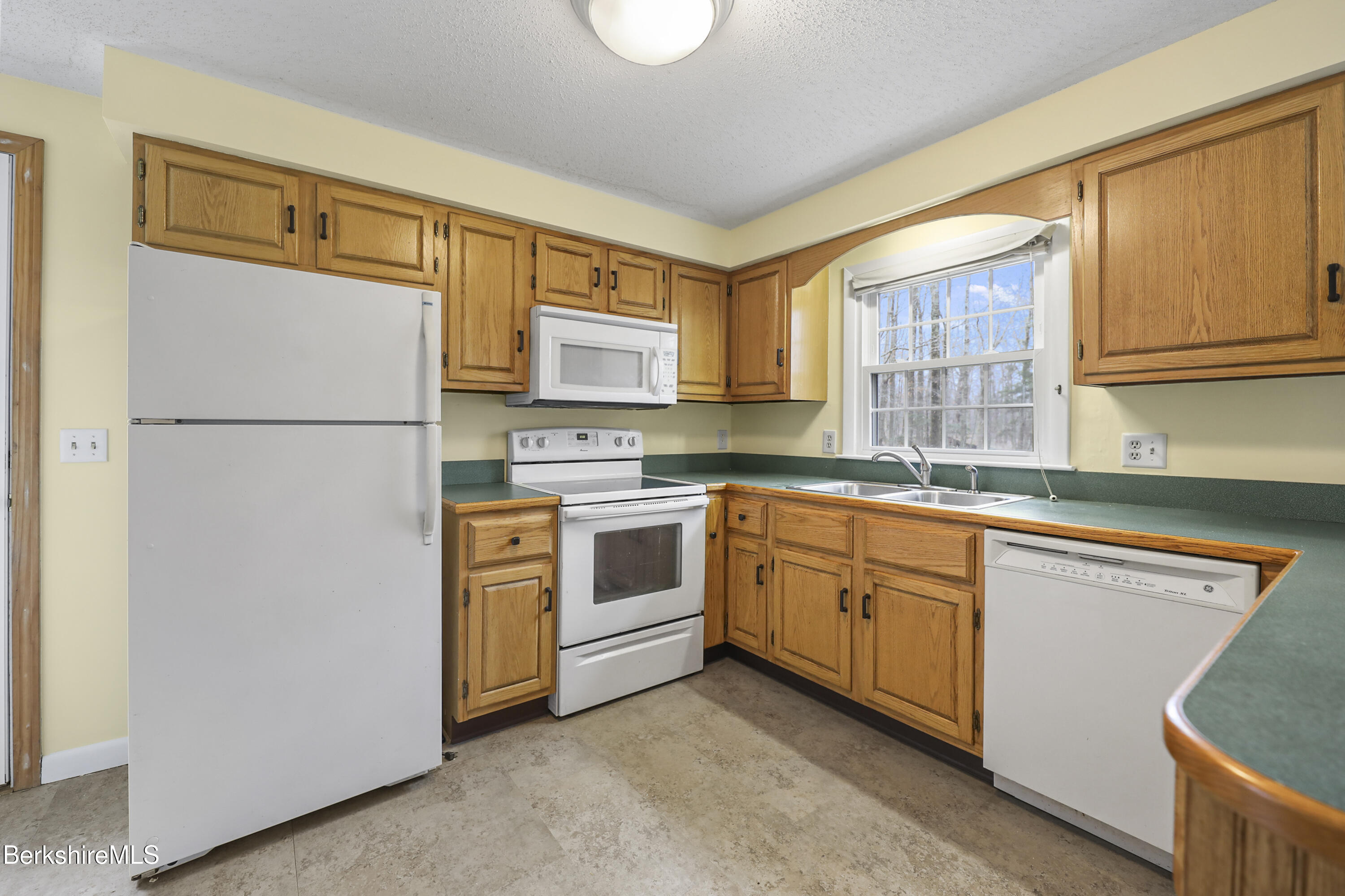 2271 Jacobs Ladder Road Becket, MA 01223 - Photo 10 of 28 a kitchen with cabinets stainless steel appliances and a window
