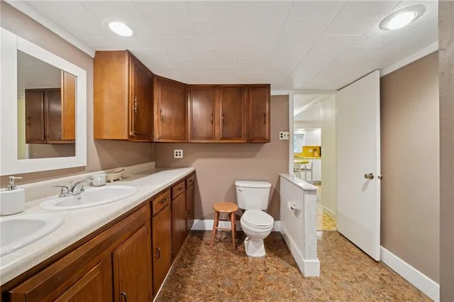 a spacious bathroom with a sink a toilet and a mirror