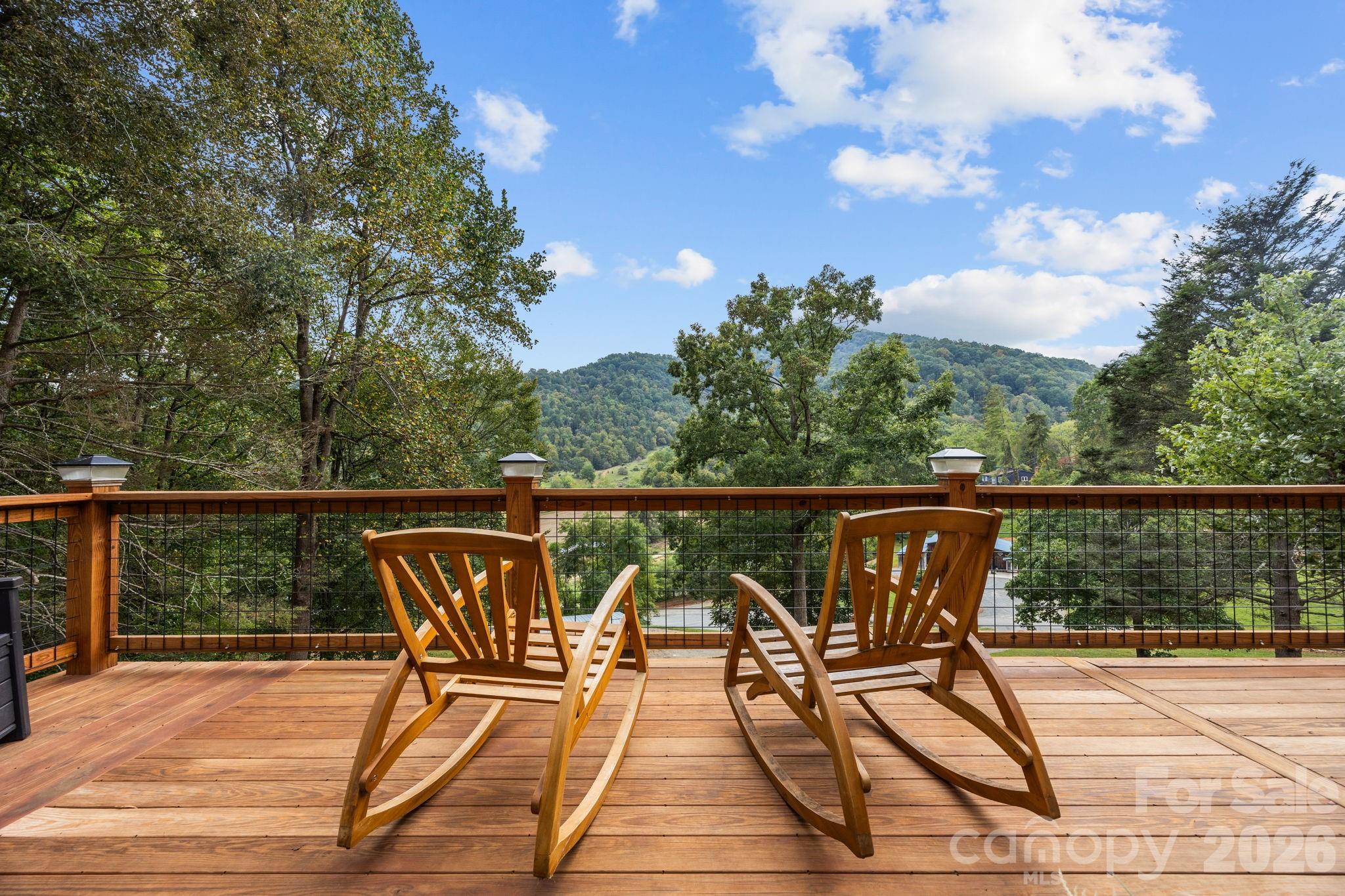 a view of a balcony with wooden floor and iron fence