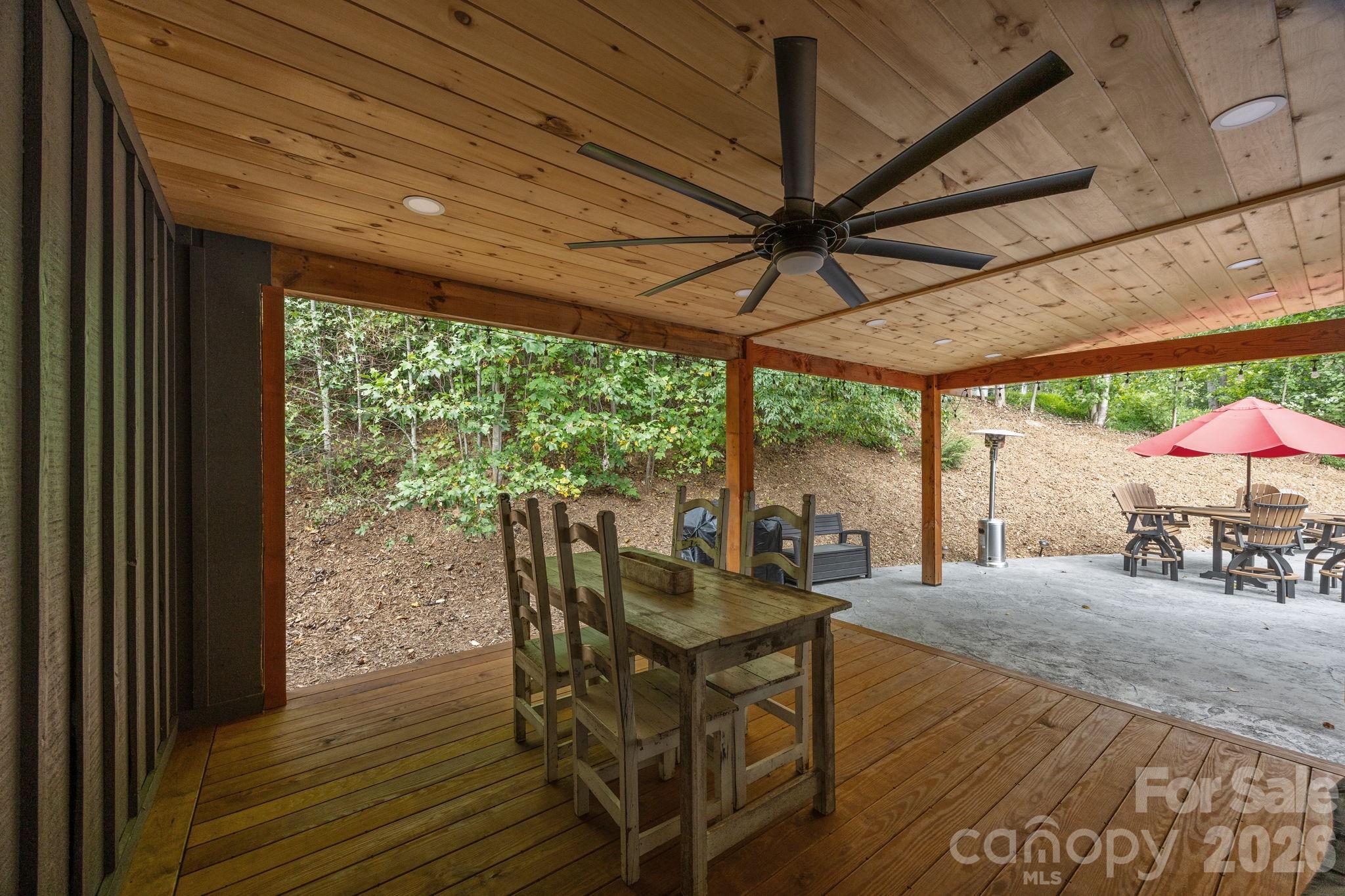 263 Morgan Branch Road, Unit 1 Leicester, NC 28748 - Photo 27 of 31 a view of a patio with table and chairs under an umbrella