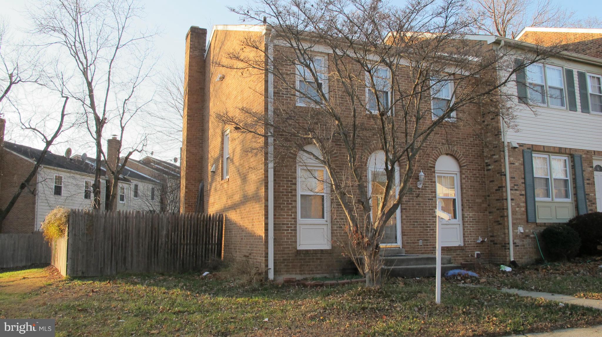 a view of a house with a yard and wooden fence