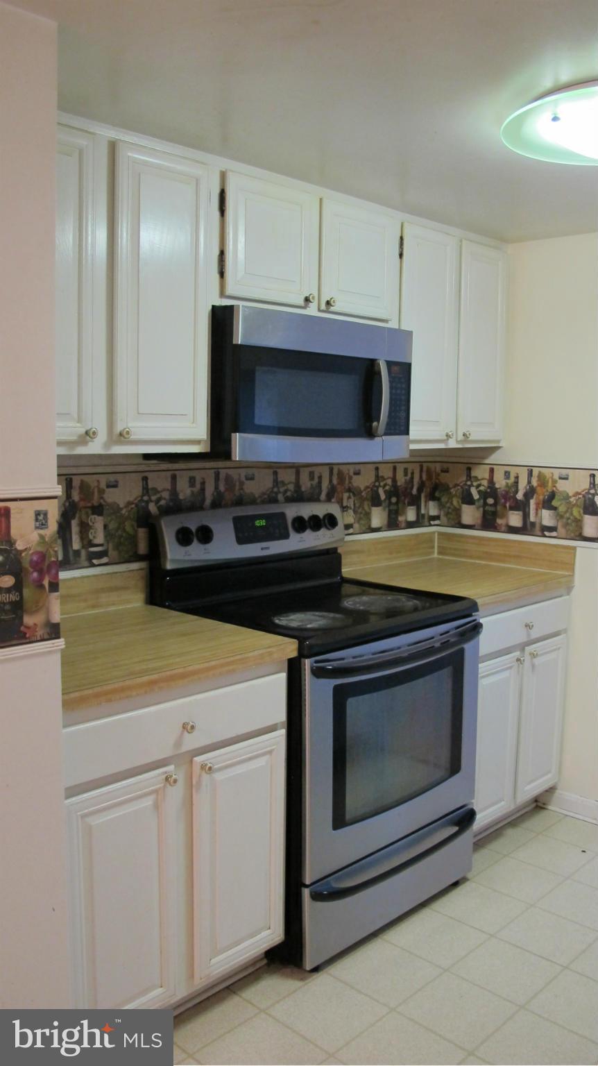 2902 Seminole Road Woodbridge, VA 22192 - Photo 18 of 24 a kitchen with stainless steel appliances granite countertop a stove a microwave and cabinets