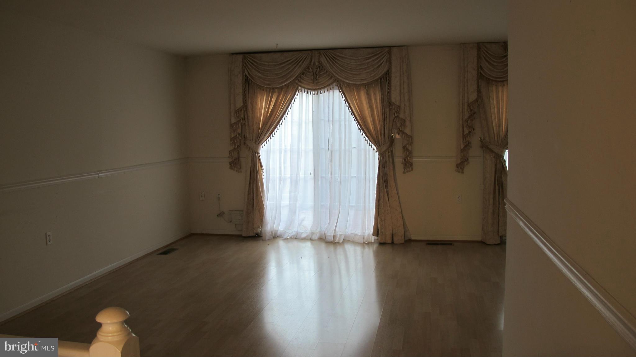 2902 Seminole Road Woodbridge, VA 22192 - Photo 5 of 24 an empty room with wooden floor and windows with curtains