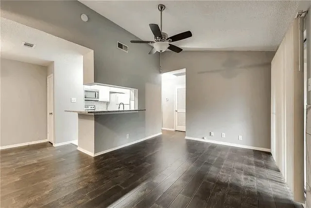 a view of a kitchen with wooden floor and a ceiling fan