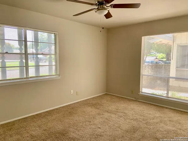 an empty room with cabinet and windows