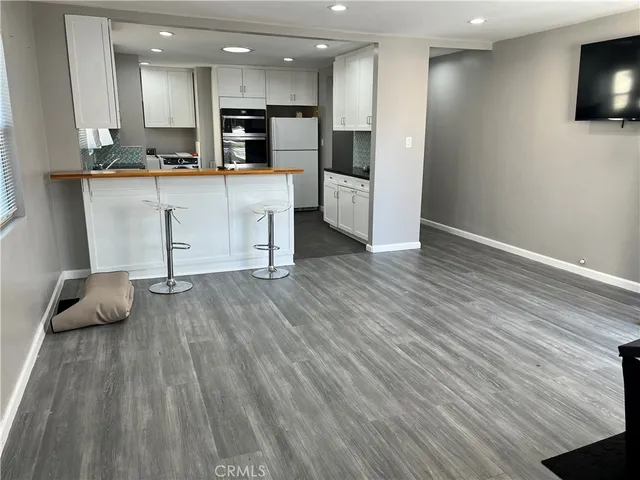a kitchen with stainless steel appliances granite countertop a refrigerator and a stove top oven