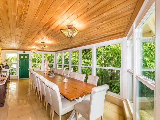 a view of a dining room with furniture large windows and wooden floor