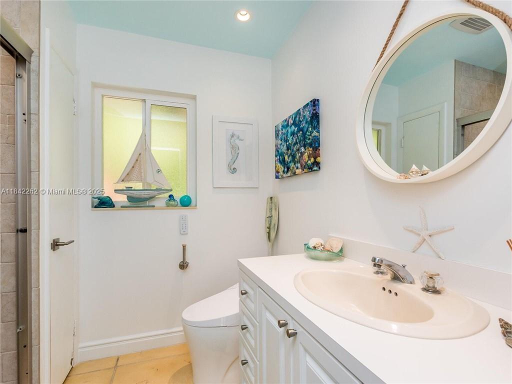 2616 Northeast 26th Avenue Lighthouse Point, FL 33064 - Photo 18 of 30 a bathroom with a sink a mirror and toilet