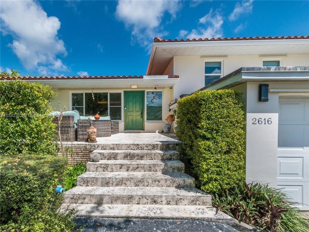 2616 Northeast 26th Avenue Lighthouse Point, FL 33064 - Photo 2 of 30 a front view of a house with a garden