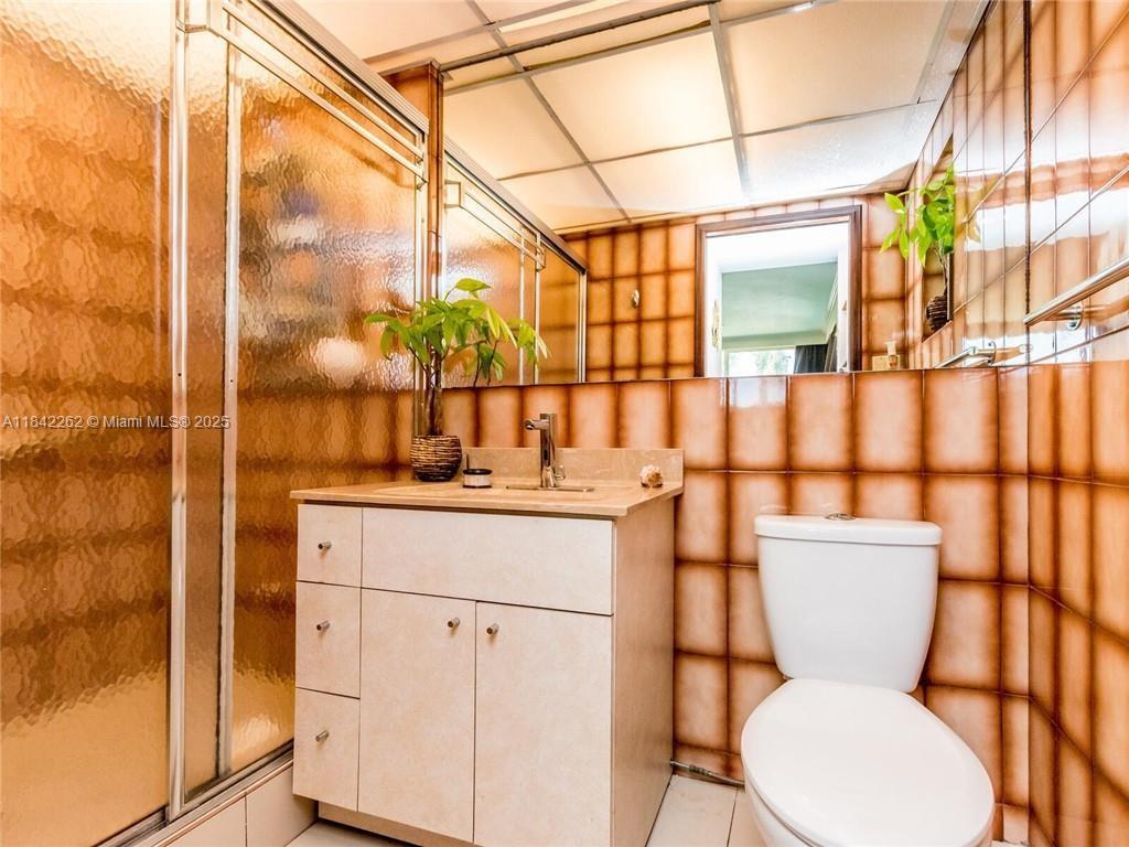 2616 Northeast 26th Avenue Lighthouse Point, FL 33064 - Photo 22 of 30 a bathroom with a toilet sink and mirror