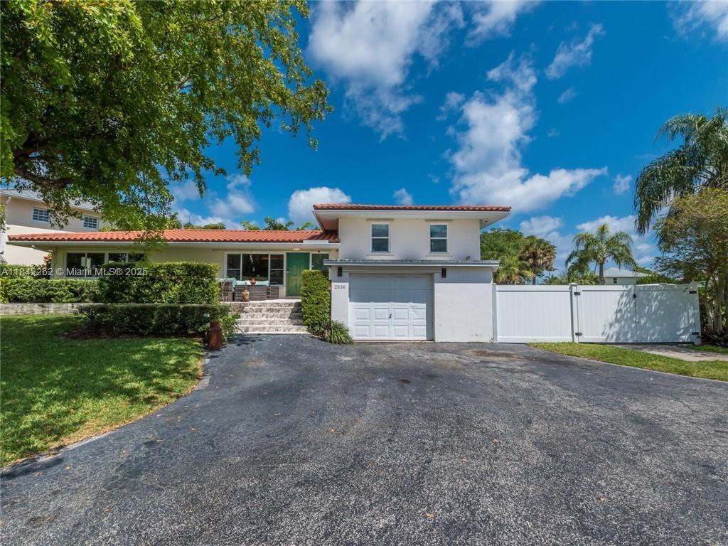 2616 Northeast 26th Avenue Lighthouse Point, FL 33064 - Photo 5 of 30 a view of a house with a yard and a large tree