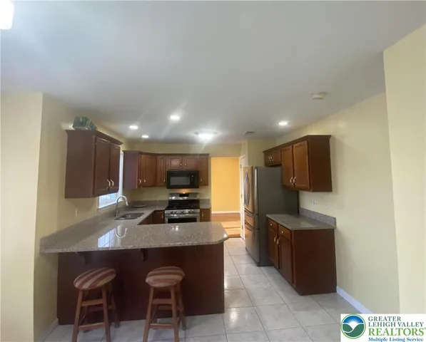 a kitchen with kitchen island a sink table and chairs