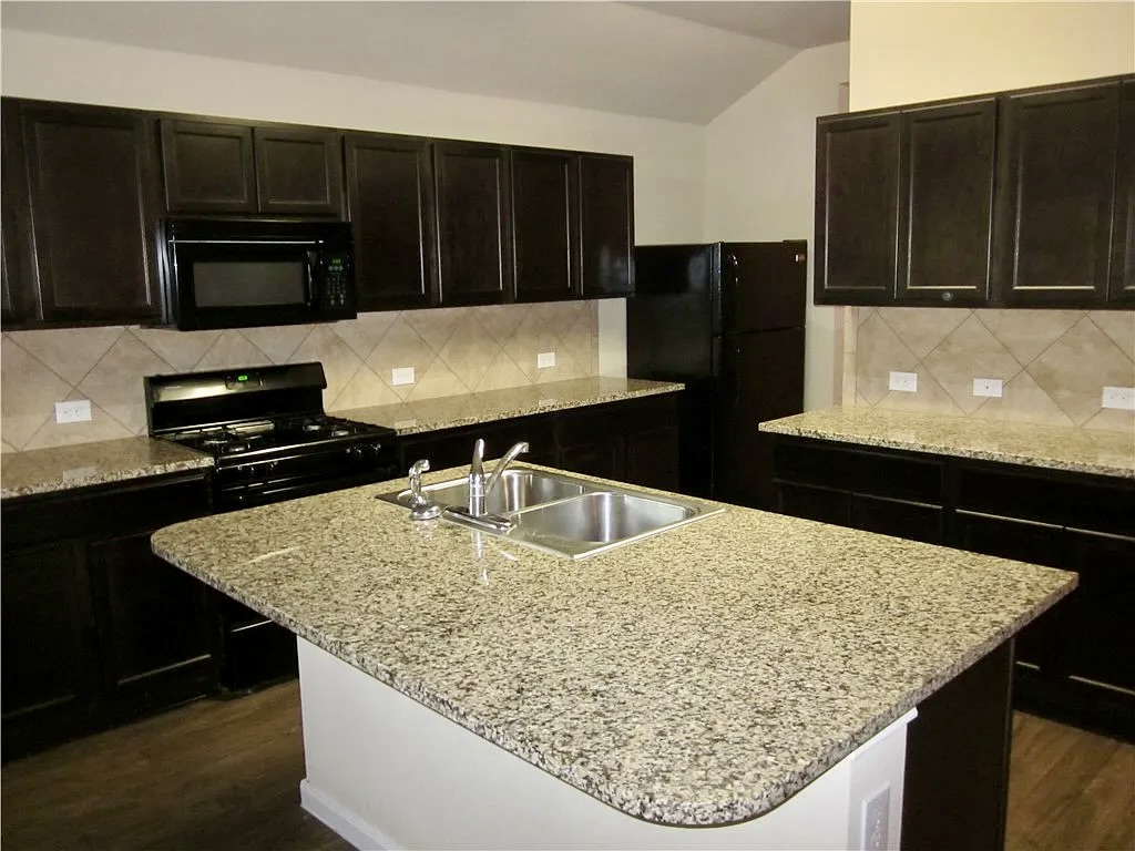 541 Alpha Kyle, TX 78640 - Photo 3 of 9 A functional kitchen with rich cabinetry and ample counter space for culinary endeavors.