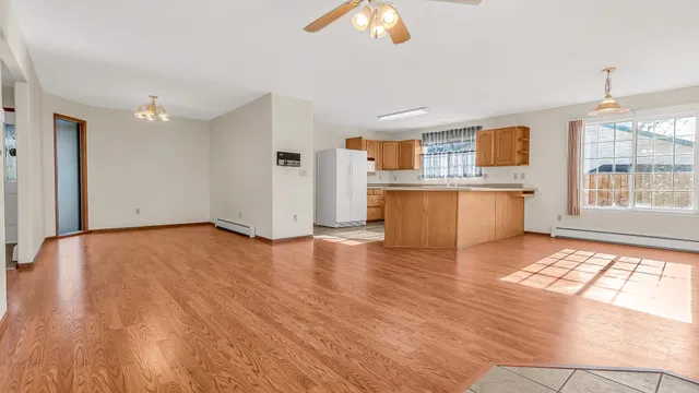 a view of kitchen with stainless steel appliances granite countertop a stove top oven a sink dishwasher and wooden floor
