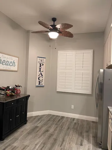 a view of room with hardwood floor and ceiling fan