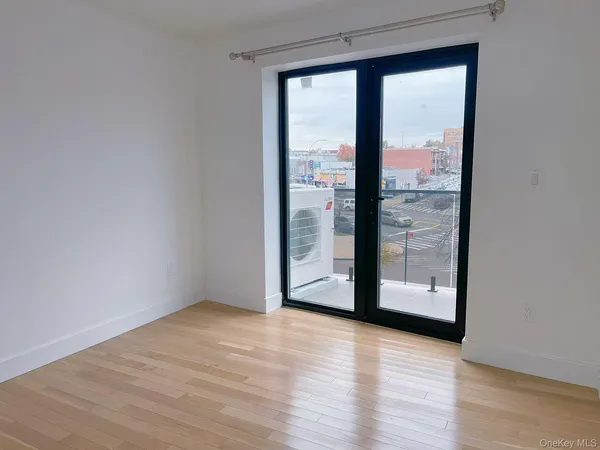 a view of a room with wooden floor and sliding glass door