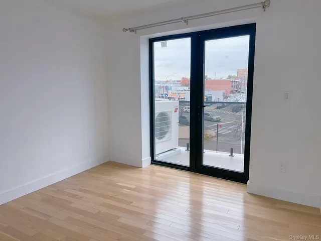 a view of a room with wooden floor and sliding glass door