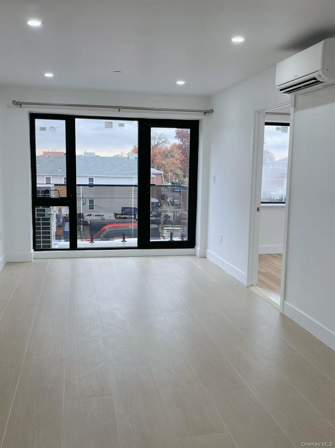 16502 Sanford Avenue, Unit 302 Queens, NY 11358 - Photo 5 of 6 an empty room with large windows