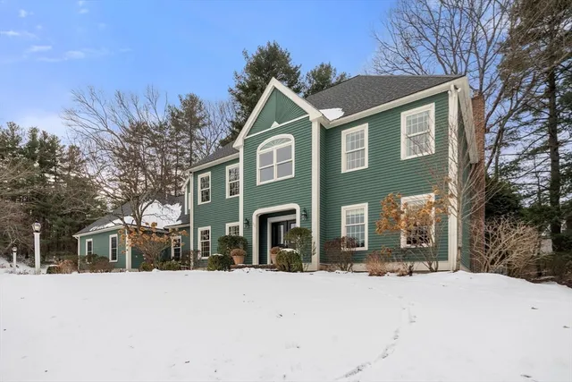 a front view of a house with a yard covered with snow