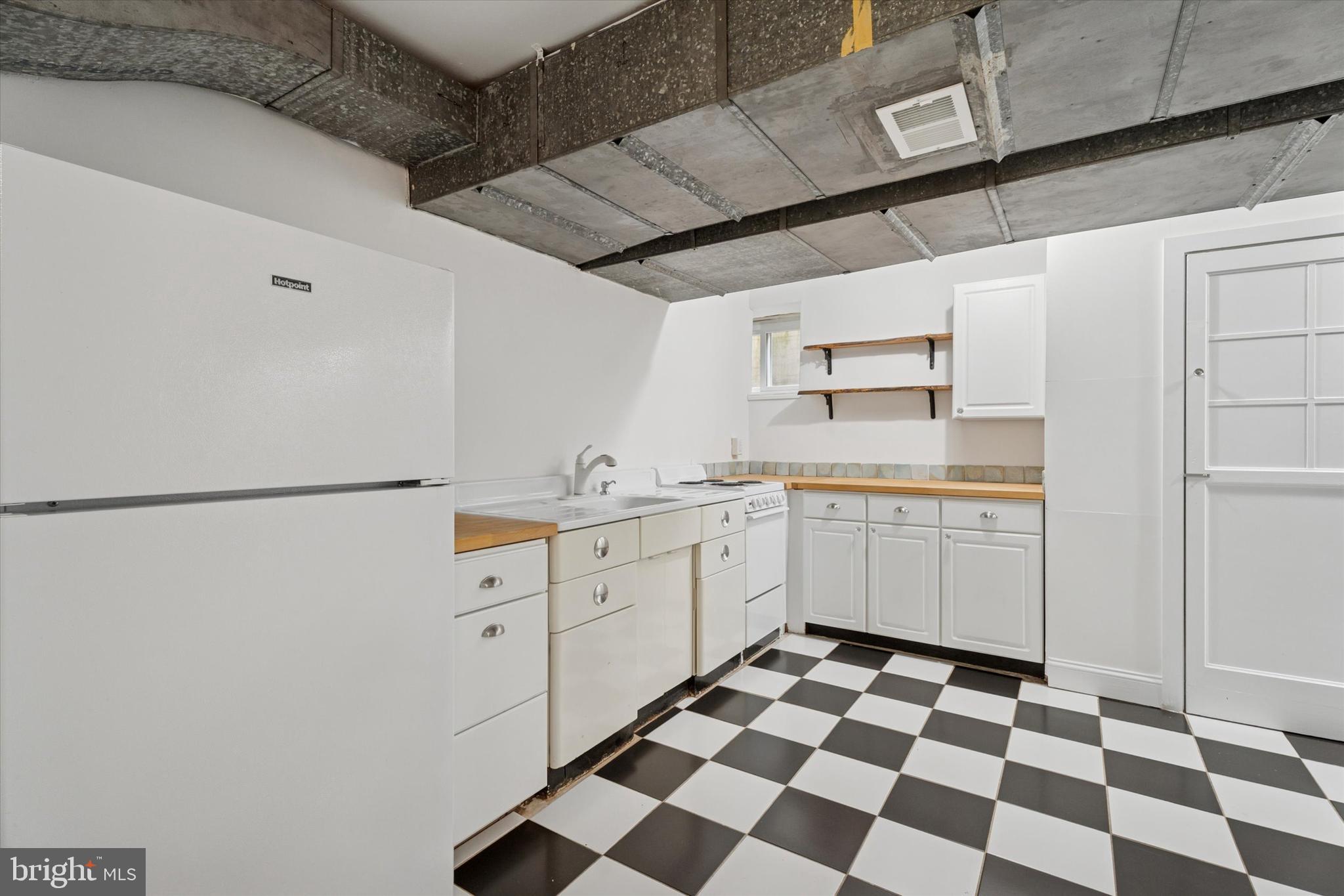 110 Raynham Road Merion Station, PA 19066 - Photo 59 of 59 a kitchen with a checkered floor and white cabinets