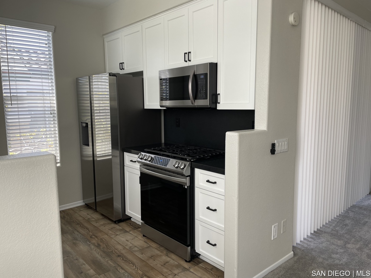 a kitchen with stainless steel appliances a stove microwave and a refrigerator