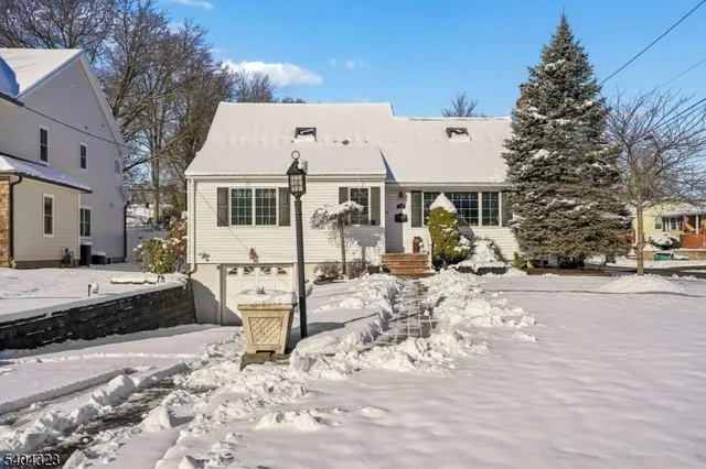 a view of a white house with a snow on the side of the road