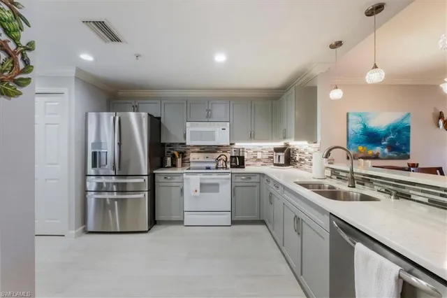 a kitchen with stainless steel appliances a refrigerator sink and stove