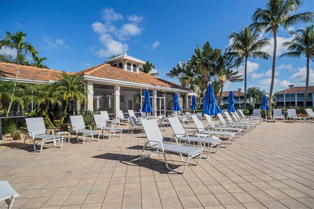 3023 Horizon Lane, Unit 2507 Naples, FL 34109 - Photo 40 of 50 a view of a patio with table and chairs potted plants and palm trees