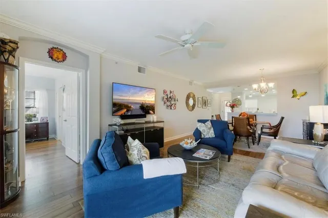 a living room with furniture kitchen view and a window