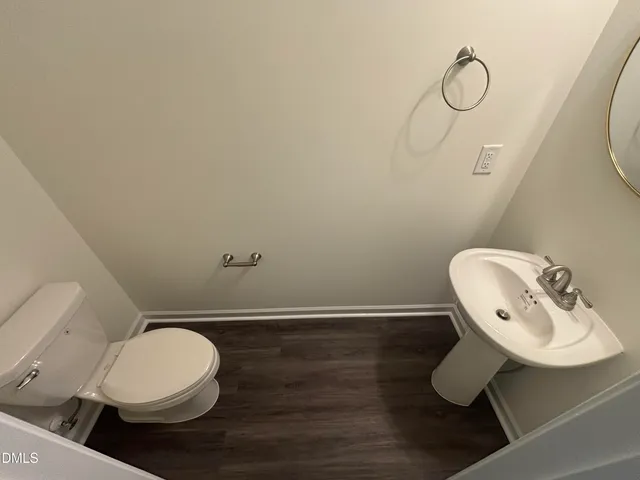 an empty room with wooden floor chandelier fan and windows