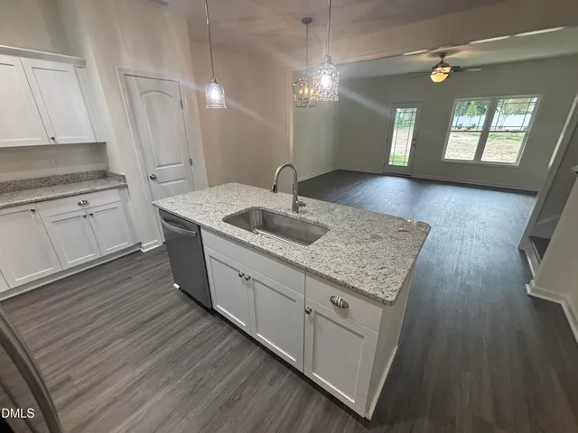 a kitchen with sink cabinets and wooden floor