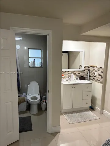 a bathroom with a sink a toilet and mirror