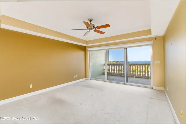 a view of a room with a window and a ceiling fan