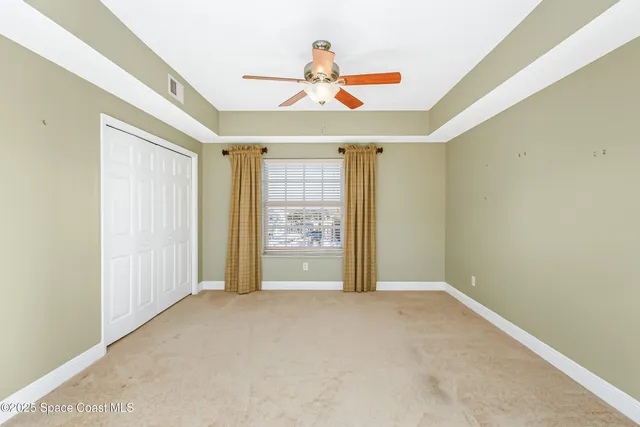 an empty room with window and ceiling fan