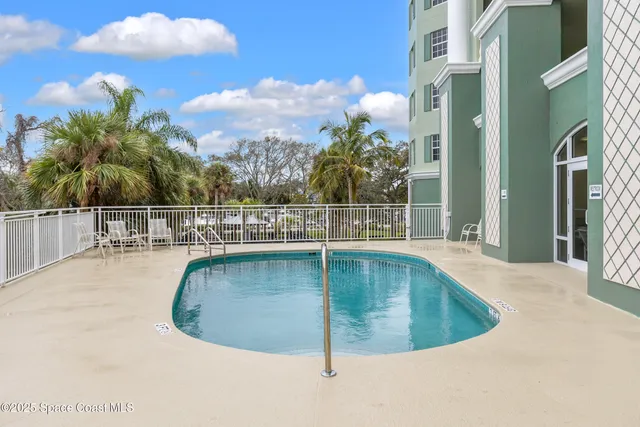 a view of a white building with a yard in front of it