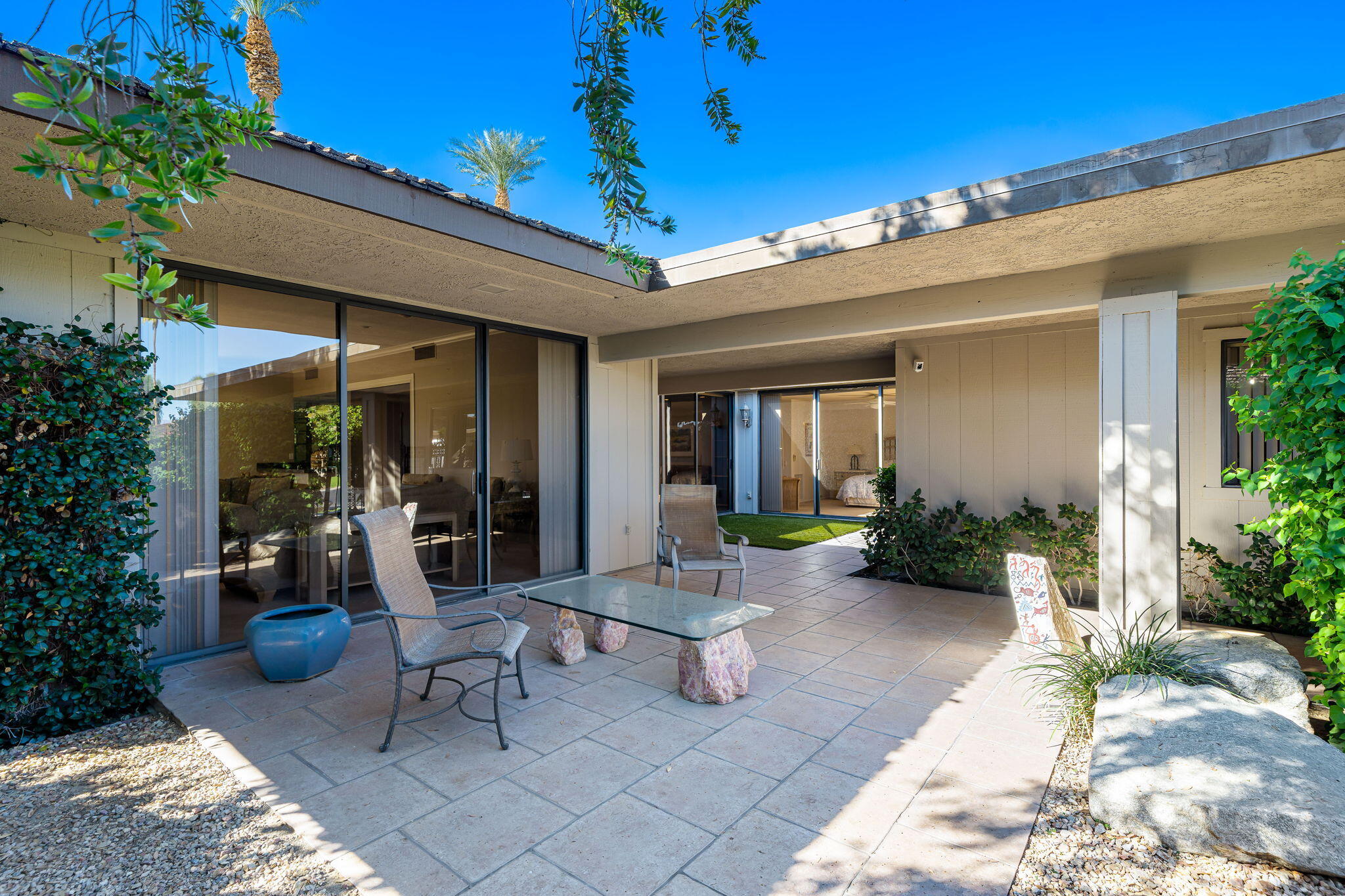 13 Duke Drive Rancho Mirage, CA 92270 - Photo 16 of 68 a view of a patio with table and chairs potted plants and floor to ceiling window and potted plants