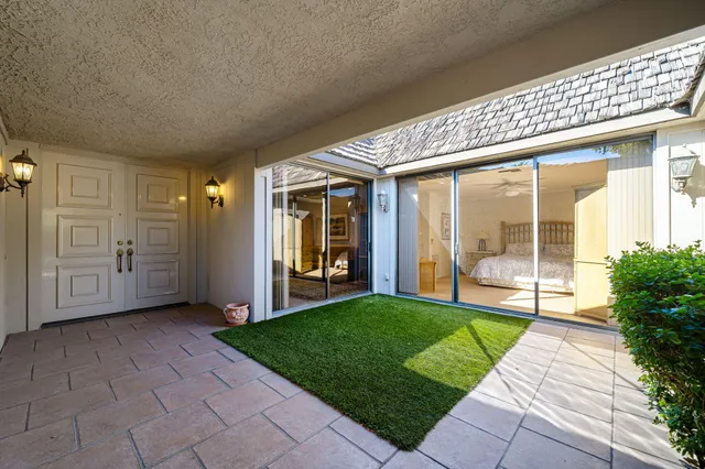 a room with patio furniture and a floor to ceiling window