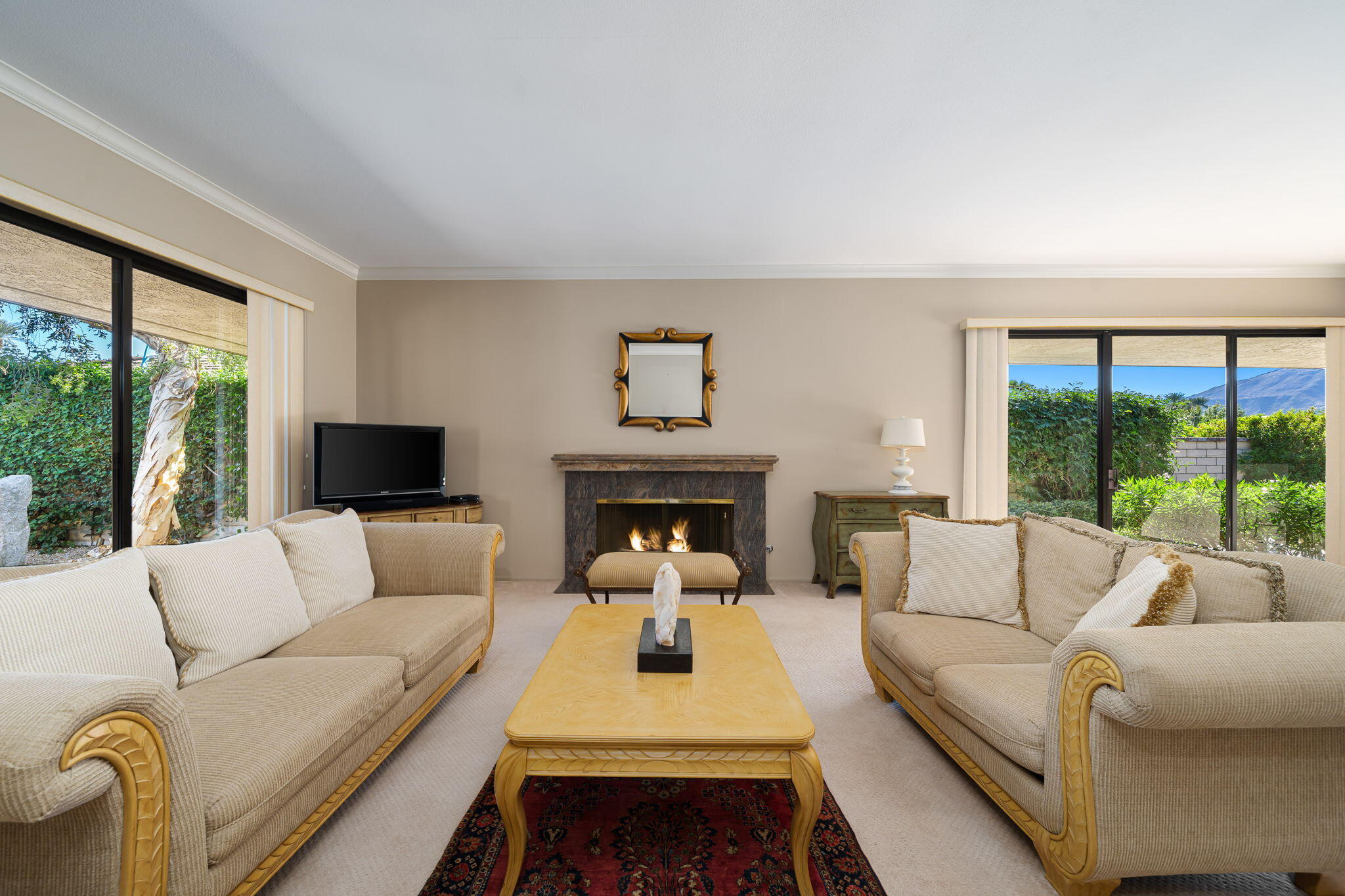 13 Duke Drive Rancho Mirage, CA 92270 - Photo 24 of 68 a living room with furniture a large window and a fireplace