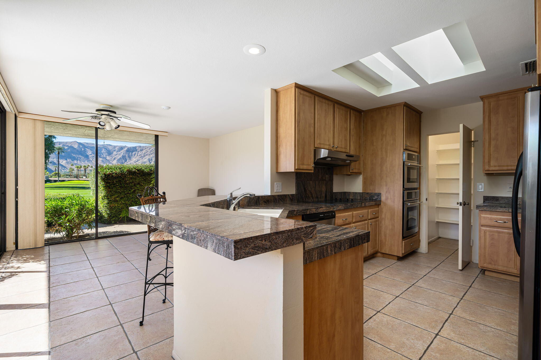 13 Duke Drive Rancho Mirage, CA 92270 - Photo 28 of 68 a kitchen with a stove a refrigerator and a view of living room