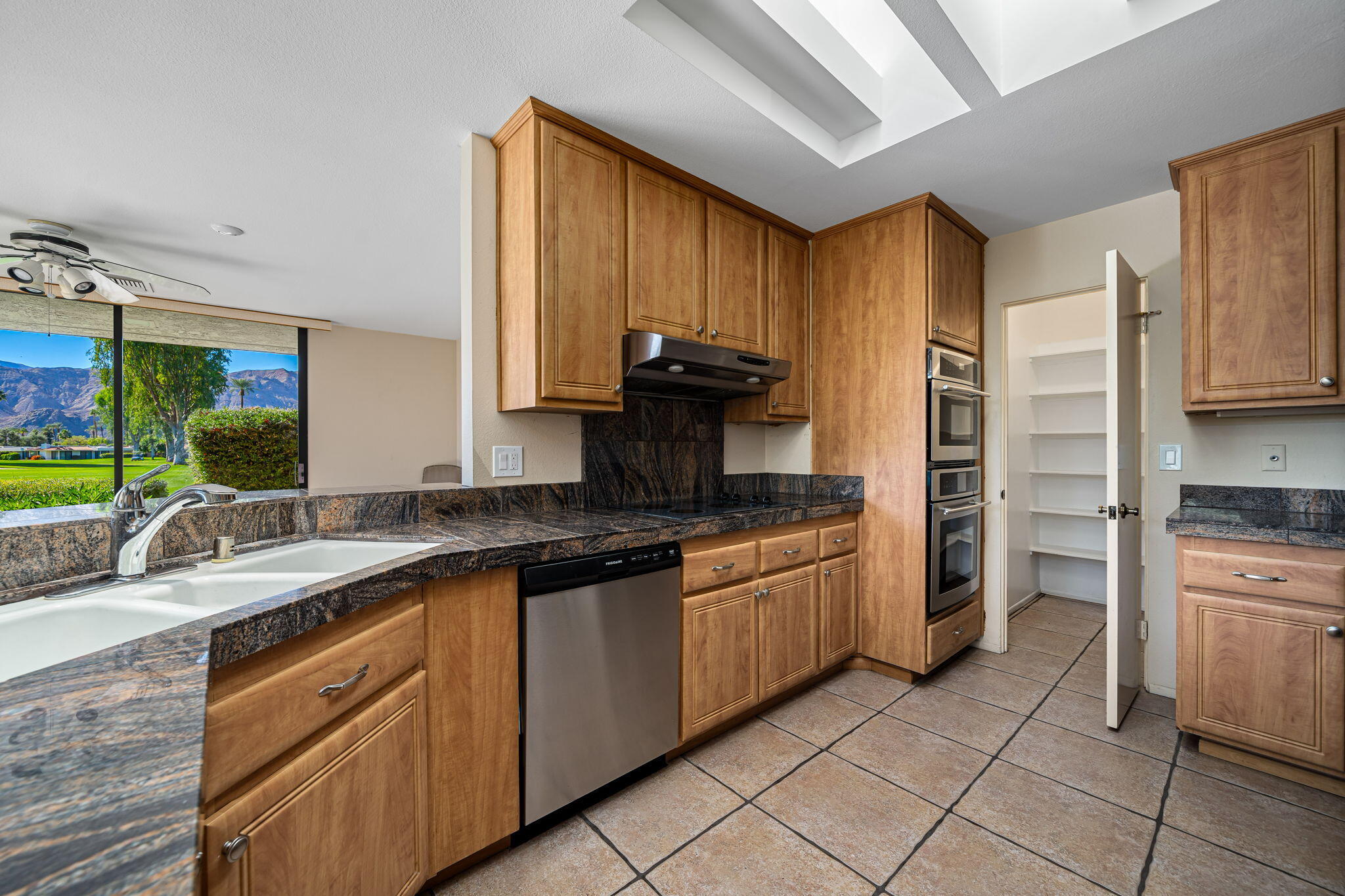 13 Duke Drive Rancho Mirage, CA 92270 - Photo 32 of 68 a kitchen with stainless steel appliances granite countertop a sink stove and refrigerator