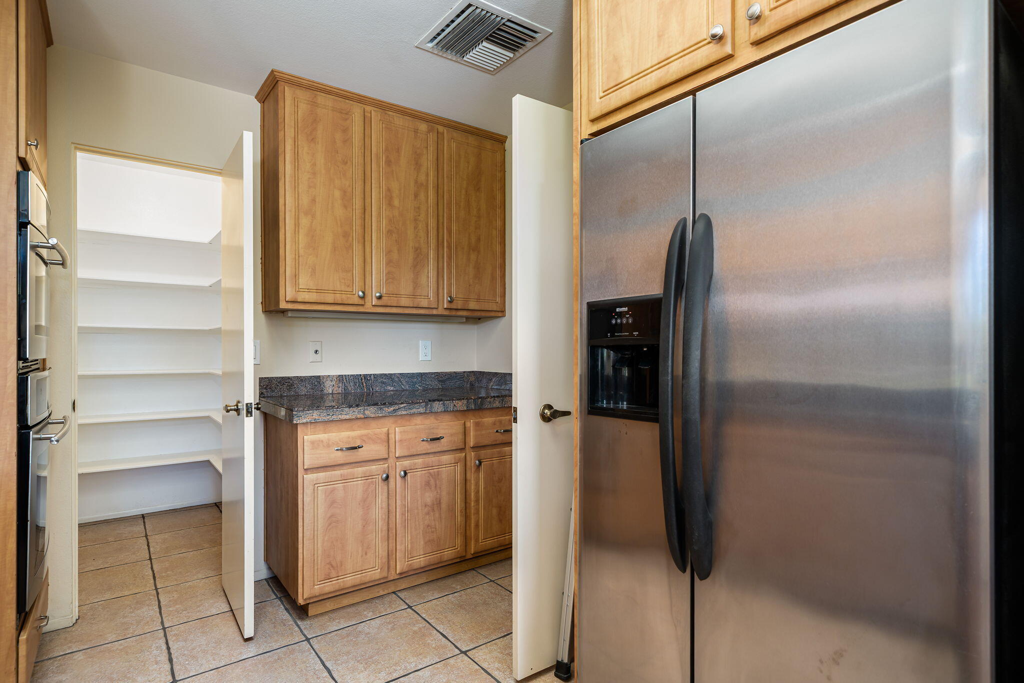 13 Duke Drive Rancho Mirage, CA 92270 - Photo 34 of 68 a kitchen with a refrigerator and cabinets