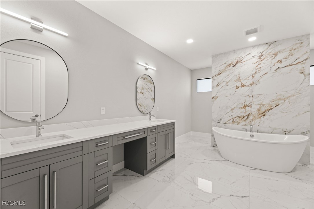 2829 Southwest 25th Place Cape Coral, FL 33914 - Photo 19 of 45 a spacious bathroom with a tub sink and mirror