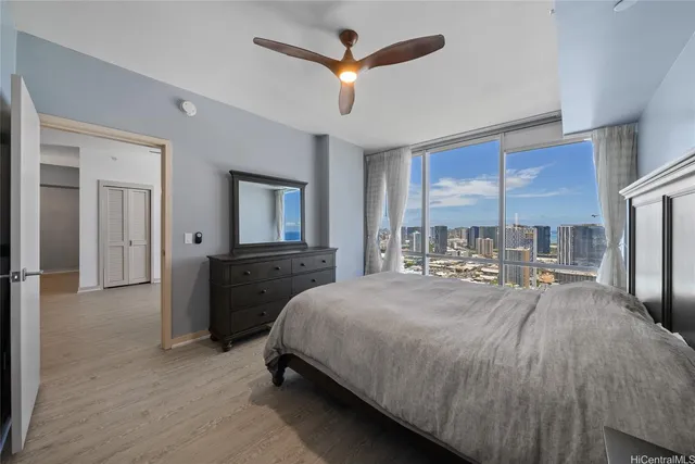 a bedroom with a bed a large window and flat screen tv