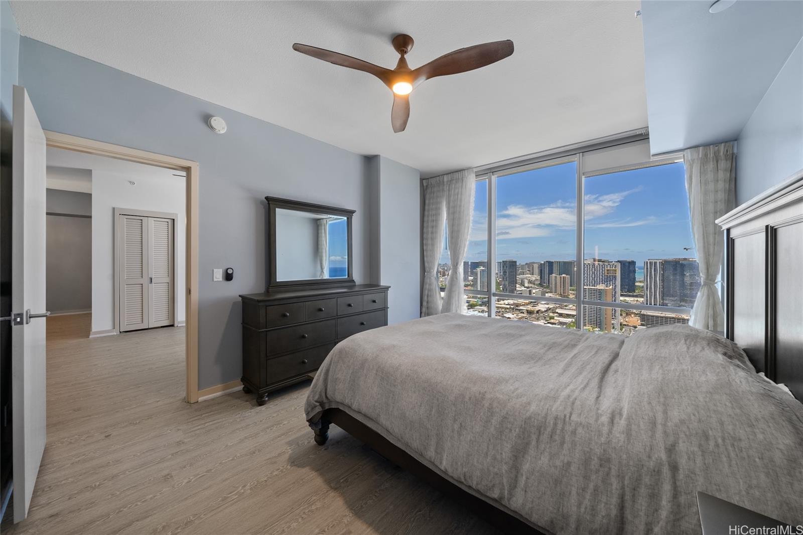 555 South Street, Unit 4202 Honolulu, HI 96813 - Photo 3 of 22 a bedroom with a bed a large window and flat screen tv