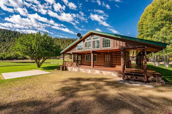a view of a house with backyard and a patio