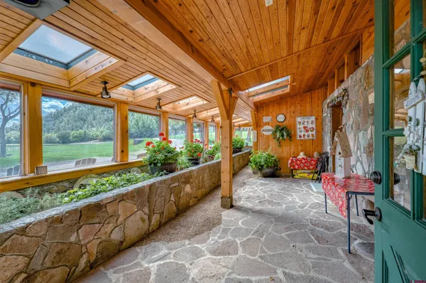 a view of a porch with furniture and garden