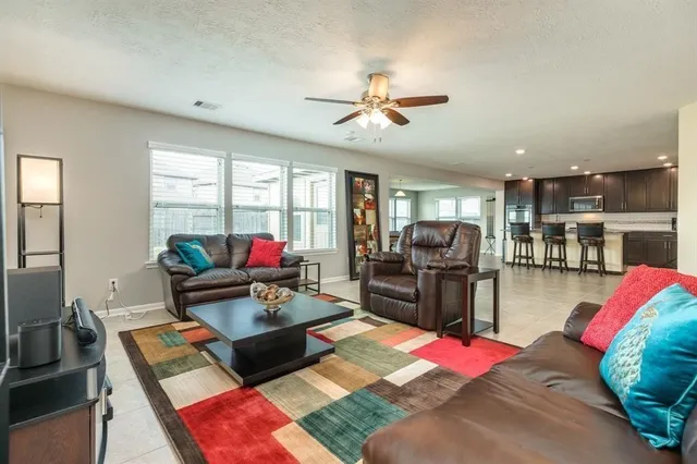 a living room with furniture and a view of kitchen