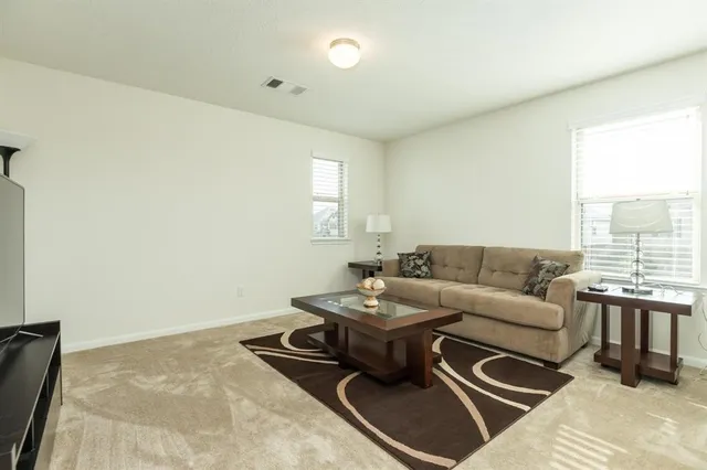a living room with furniture a large window and a wooden floor