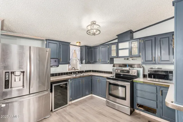 a kitchen with stainless steel appliances granite countertop a refrigerator stove a sink and dishwasher