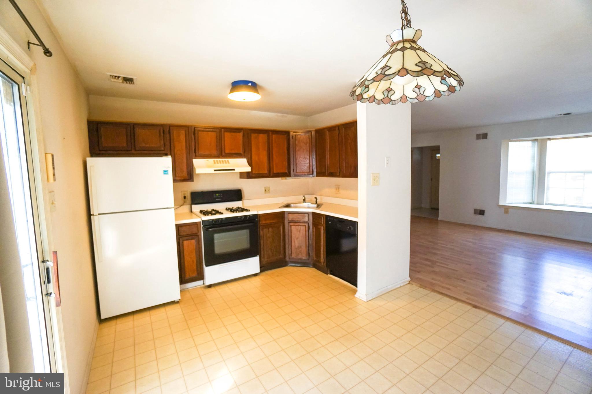 216 Danbury Drive Little Egg Harbor, NJ 08087 - Photo 9 of 19 a kitchen with stainless steel appliances granite countertop a refrigerator a sink dishwasher a stove and a dining table with wooden floor